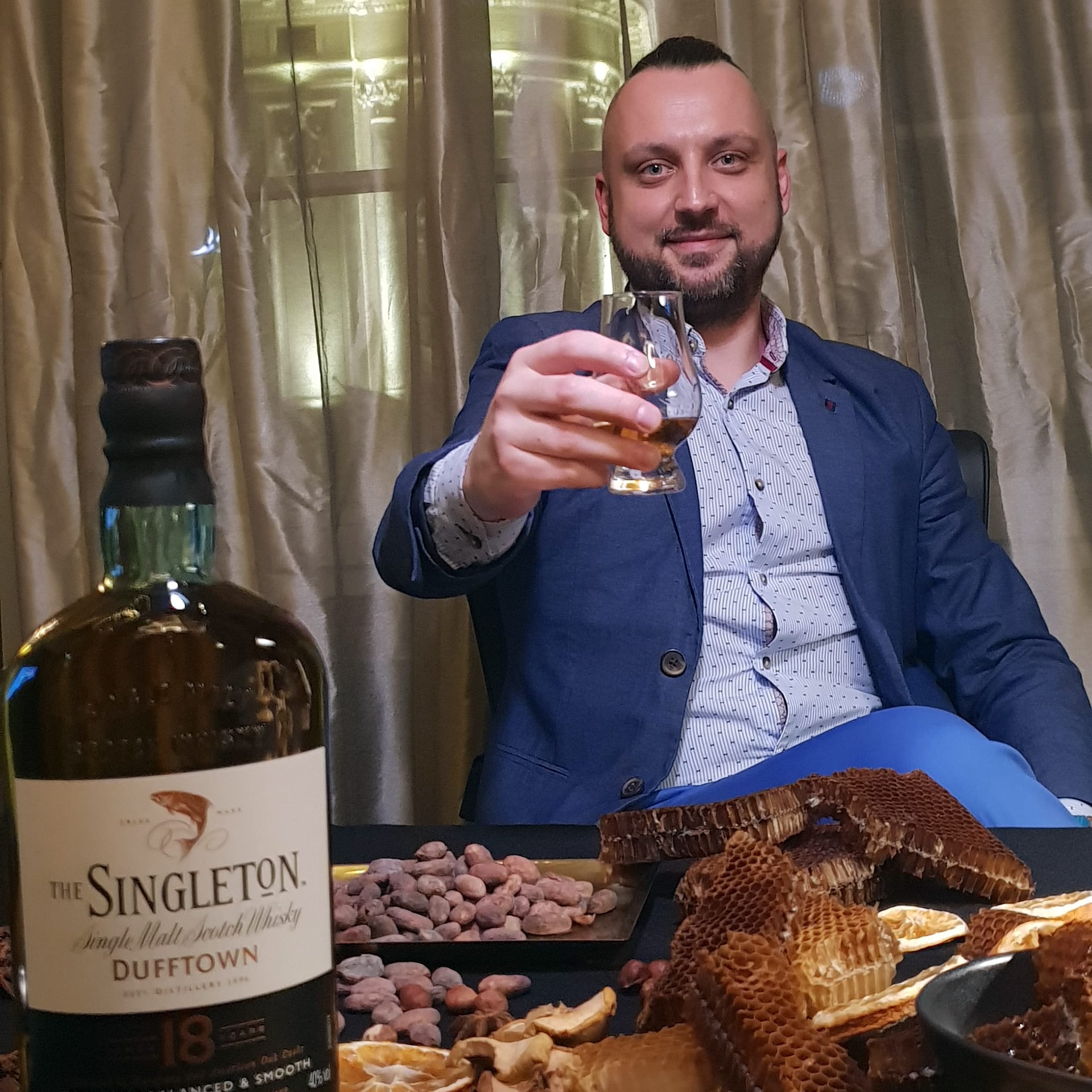 Whisky Singleton - toast wznoszony przez mężczyznę w ciepłym nastroju